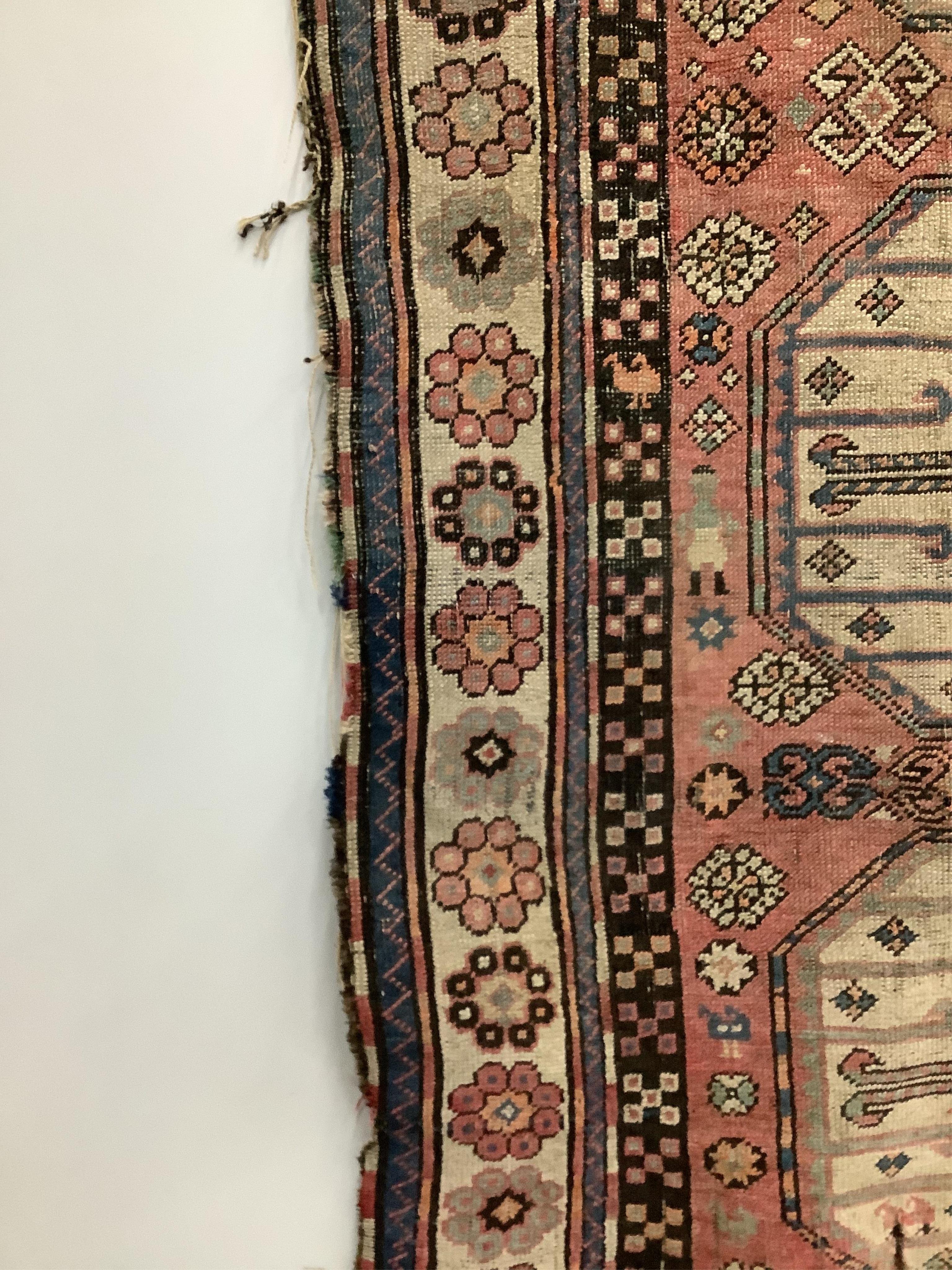 A Caucasian red ground rug, 265 x 130cm. Condition - faded with some wear at the margins